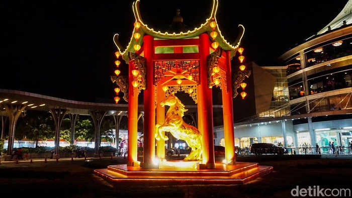 Pengunjung melintas di depan dekorasi patung kuda bertema Imlek di pusat perbelanjaan Margo City, Depok, Jumat (6/2/2026). Dekorasi tersebut dihadirkan untuk menyemarakkan perayaan Tahun Baru Imlek 2026 sekaligus menarik minat masyarakat berkunjung.