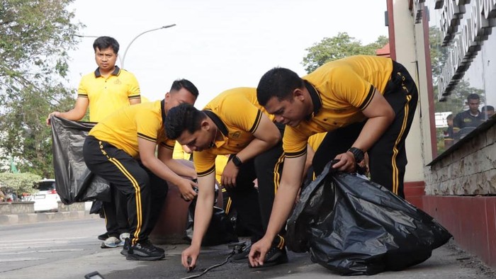 Personel Polres Grobogan saat membersihkan sampah di jalan hingga objek wisata.