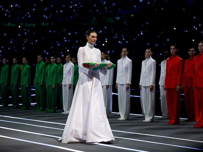 Mengutip Vogue Italia, Ceretti mengenakan gaun putih panjang rancangan khusus Armani Privé dengan lengan panjang dan kerah tinggi saat membawakan bendera Italia.  Foto: Getty Images/Elsa