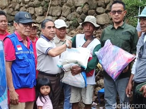 Jajaran Pemkot Bima, menyerahkan bantuan tanggap darurat pada Ahmad Kasim, pemilikrumah yang hancur rata dengan tanah tertimpa batu besar jatuh dari tebing saat hujan deras, Minggu, (8/2/2026). (Dok. Rafiin/detikBali)