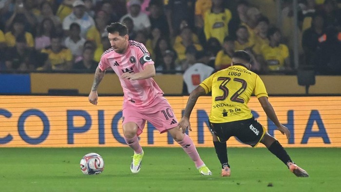 Inter Miamis Argentine forward #10 Lionel Messi runs with the ball past Barcelonas Argentine midfielder #32 Matias Lugo during the friendly football match between Ecuadors Barcelona and the US Inter Miami at the Banco Pichincha Stadium in Guayaqu