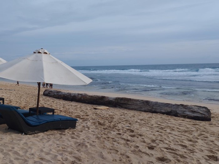 Pantai yang panjang, pasir kecokelatan, laut toska, serta sepi dari wisatawan menjadi daya tarik Pantai Nunggalan, Badung, Bali.