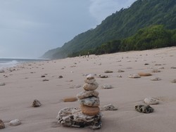 Pantai Nunggalan memiliki pasir kecokelatan dan latar bukit hijau. Pantai di Badung ini juga masih sepi dari wisatawan.&nbsp;detikers&nbsp;cukup membayar parkir motor Rp 5.000 dan tak ada tiket untuk masuk ke Pantai Nunggalan.