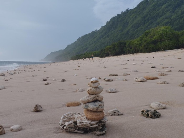 Pantai Nunggalan, Badung, Bali, Sabtu (7/2/2026). Pantai dengan pasir kecokelatan dan latar bukit hijau menjadi daya tarik wisatawan untuk mengunjunginya.