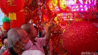 Lampion merah dengan beragam ukuran dan motif tampak menggantung di depan toko, menarik perhatian pengunjung yang melintas.