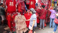 Deretan pakaian bernuansa merah dan emas dipajang di etalase toko, menjadi incaran warga untuk dikenakan saat perayaan Imlek.
