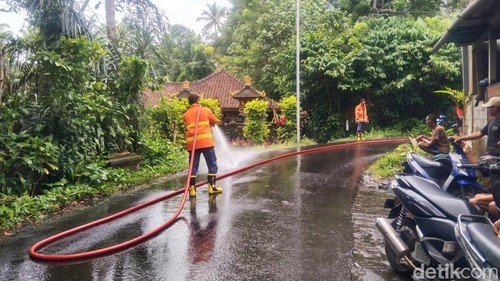 Petugas Damkartan Karangasem membersihkan ceceran solar di Banjar Dinas Tihingseka, Desa Bebandem, Karangasem, Senin (9/2/2026).