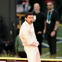 Celana chino putih bersihnya jatuh sempurna di atas sepatu adidas BadBo 1.0 warna krem. Sneakers buah kolaborasi Bad Bunny dan adidas tersebut sekaligus diperkenalkan secara perdana sebelum dirilis keesokan harinya. (Foto: Neilson Barnard/Getty Images)