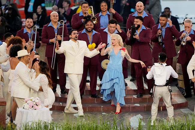 Lady Gaga dan Ricky Martin juga menyumbangkan sebuah lagu di tengah. Penampilan tersebut sebenarnya bisa memberi kesempatan bagi Bad Bunny untuk berganti kostum. Namun, mantan kekasih Kendall Jenner ini tetap setia pada tema, kembali tampil dengan busana berwarna senada, tapi kali ini dengan blazer double-breasted.  perubahan yang begitu subtil hingga mungkin luput dari perhatian banyak penonton. (Foto: Thearon W. Henderson/Getty Images)