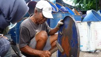 Di sudut lain bengkel, drum-drum yang telah dipotong mulai memasuki tahap penyempurnaan. Beberapa diberi tambahan pegangan besi, sementara lainnya disiapkan untuk dicat sesuai pesanan pelanggan.
