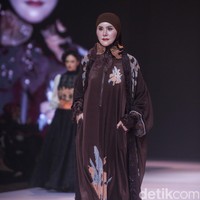 Angel Lelga mengenakan busana karya Lia Soraya, yang menonjolkan perpaduan bahan satin cokelat tua dengan aksen bordir floral yang artistik. Foto: Gilang Faturahman/detikFoto.