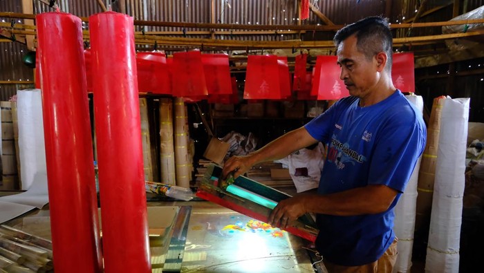 Dua pekerja mencairkan dan menuangkan cairan lilin ke dalam cetakan berukuran besar di industri rumahan pembuatan lilin milik Susanto di Desa Punggur Kecil, Kecamatan Sungai Kakap, Kabupaten Kubu Raya, Kalimantan Barat, Senin (9/2/2026). Usaha pembuatan lilin yang telah berjalan selama 15 tahun tersebut memproduksi lilin sembahyang untuk klenteng dengan ukuran mulai dari kecil hingga mencapai setinggi dua meter, dengan harga dari ribuan hingga jutaan rupiah per pasang yang dipasarkan di wilayah Kalimantan Barat. ANTARA FOTO/Jessica Wuysang/wsj.