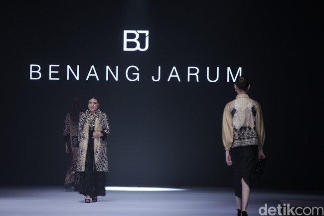 Istri Ketua MPR Bambang Soesatyo, Dewi Bamsoet, tampil sangat elegan di atas runway mengenakan outer bermotif etnik yang mewah dengan perpaduan detail payet yang berkilau. Dewi membawakan koleksi dari Benang Jarum. Foto: Gilang Faturahman/detikFoto