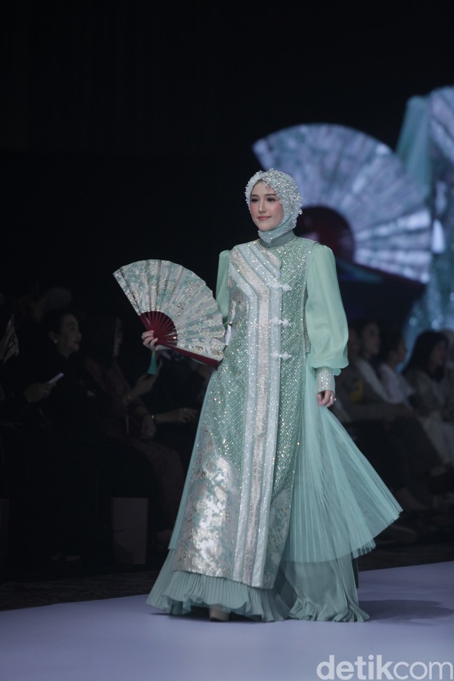 Istri anggota DPR sekaligus vokalis Ungi, Pasha, Adelia Pasha tampil menawan dalam balutan busana muslim bernuansa hijau sage karya Lina Sukijo yang memadukan detail payet mewah dengan aksen bordir geometris yang elegan.  Foto: Gilang Faturahman/detikFoto.