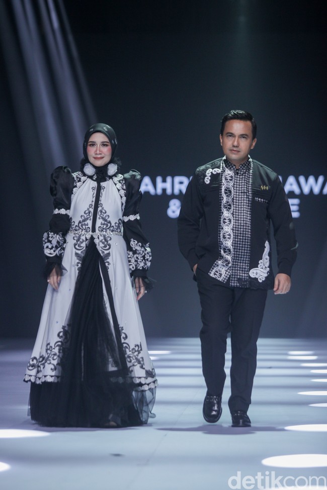 Sahrul Gunawan tampil karismatik dalam balutan kemeja hitam dari Motif Hawa yang dihiasi detail bordir putih vertikal yang memberikan kesan maskulin namun tetap serasi dengan sang istri, Dine Mutiara. Foto: Gilang Faturahman/detikFoto.