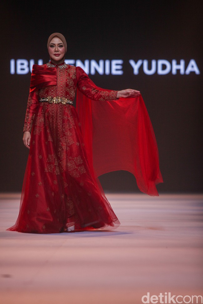 Ketua Bhayangkari Daerah Kalimantan Selatan Yennie Yudha tampil dalam balutan gaun merah mewah yang dihiasi bordir emas, lengkap dengan aksen jubah transparan. Foto: Gilang Faturahman/detikFoto.