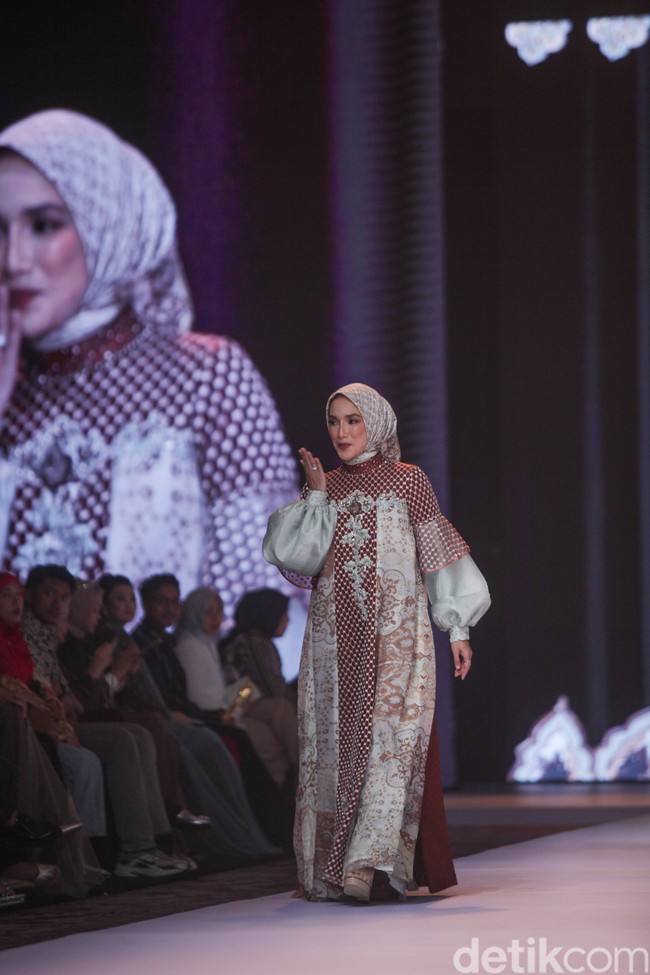 Ussy Sulistiawaty tampil sangat anggun dalam balutan busana Arabelle yang memadukan siluet modern dengan motif etnik yang mewah. Foto: Gilang Faturahman/detikFoto.