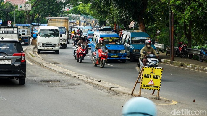 Kondisi jalan berlubang terlihat di Jalan Raya Bogor, kawasan Cimanggis, Kota Depok, Rabu (11/2/2026). Lubang yang cukup dalam tersebut dinilai membahayakan keselamatan pengguna jalan, terutama pengendara sepeda motor yang melintas di jalur tersebut.