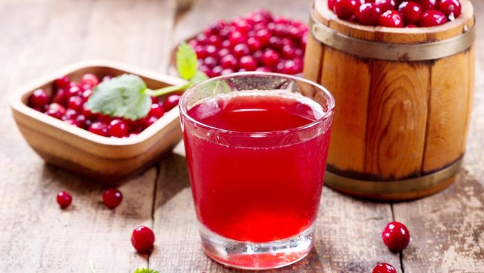 glass of cranberry juice with fresh berries on wooden table