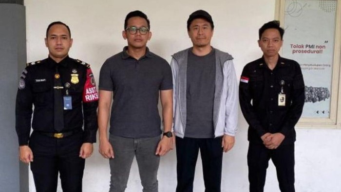Liu Xiaodong (jaket abu-abu) saat diamankan petugas Kantor Imigrasi Entikong, Kabupaten Sanggau di jalur perbatasan Indonesia-Malaysia. (Istimewa)