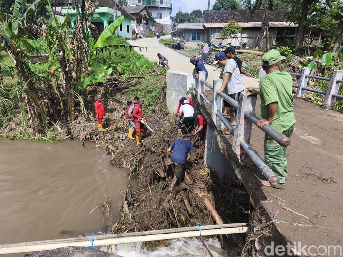 Warga membersihkan Jembatan Sungai Karangmalang, Kecamatan Mijen, Kota Semarang dari material kayu, Rabu (11/2/2026).
