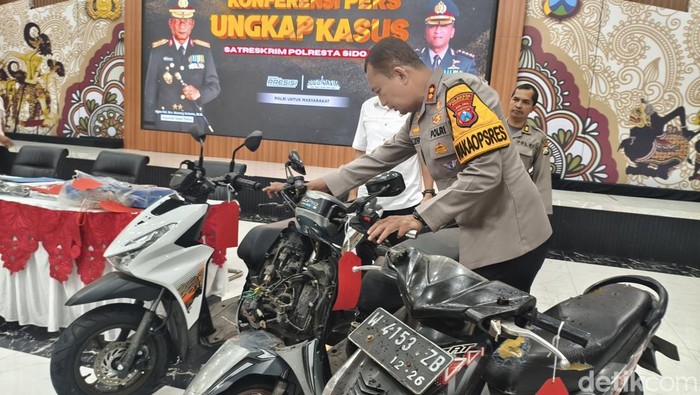 Polisi saat menunjukkan motor hasil rampasan komplotan penipu anak di Sidoarjo.