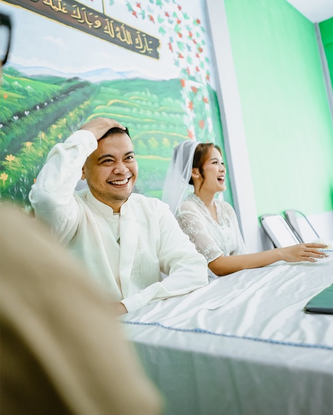 Santi, sang mempelai wanita, cantik bersahaja dengan tunik berhias bordir dan rok panjang. Obi dengan detail renda dan sneakers adidas melengkapi penampilannya. Foto: Instagram/@mrezanugrah