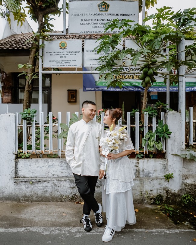 Keduanya juga memilih tampilan sederhana untuk meresmikan hubungan mereka. Reza tampak mengenakan baju koko putih dengan bordiran halus, dipadu celana hitam. Foto: Instagram/@mrezanugrah