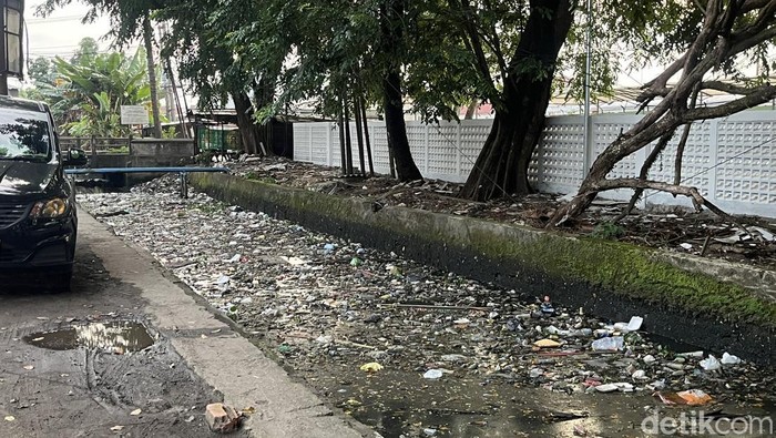 Tumpukan sampah terlihat memenuhi saluran drainase Jalan Ki Marogan, Palembang