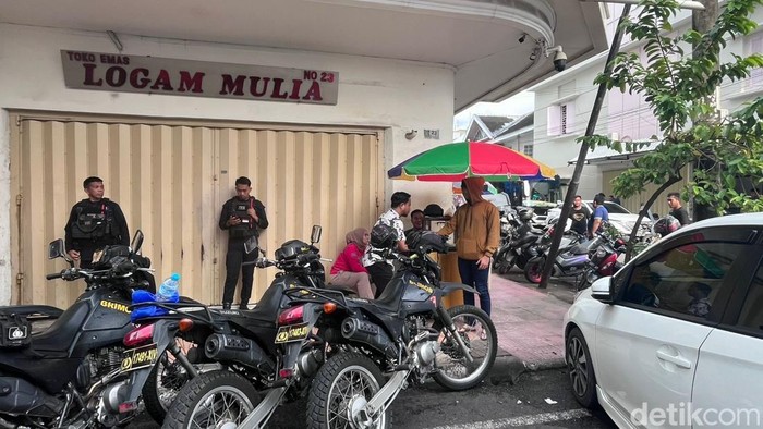 Aparat kepolisian berjaga di Toko Emas Logam Mulia Makassar usai dibakar menggunakan bom molotov.