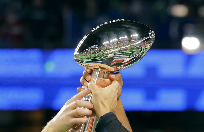 Piala Super Bowl 2026 Buatan Tiffany & Co. Football - NFL - Super Bowl LX - New England Patriots v Seattle Seahawks - Levi's Stadium, Santa Clara, California, United States - February 8, 2026 Seattle Seahawks players hold aloft the Vince Lombardi Trophy as they celebrate after winning Super Bowl LX REUTERS/Mike Blake