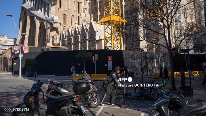 A man cleans broken glass on the floor of a terrace next to Sagrada Familia Basilica amid a strong wind alert due to Storm Nils in Barcelona, on February 12, 2026. Powerful winds topping 100 kilometres per hour (62 mph) battered Spains northeastern 