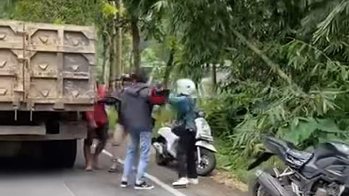 Tangkapan layar video saat pengendara lain melerai pertikaian antara sopir truk dan seorang pengendara motor.