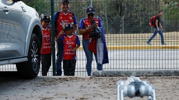 Kehadiran robot ini juga menarik perhatian masyarakat, termasuk keluarga yang menyaksikan langsung demonstrasi tersebut di area stadion. REUTERS/Daniel Becerril