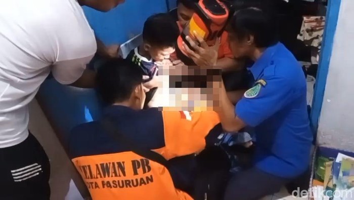Bocah di Pasuruan yang kelaminnya terjepit ritsleting saat ditangani oleh Petugas Damkar.