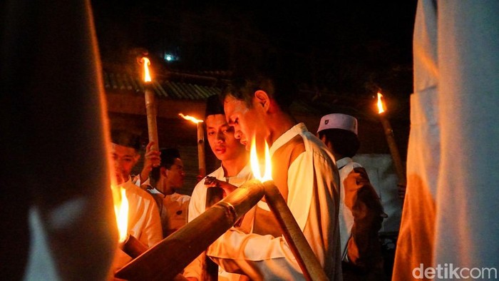 Cahaya obor menyala menerangi malam di Perkampungan Budaya Betawi saat ratusan warga mengikuti pawai obor untuk menyambut datangnya bulan suci Ramadan, Jumat (13/2/2026). Deretan obor bambu yang menyala membentuk garis cahaya memanjang, mengiringi langkah para peserta sepanjang rute pawai.
