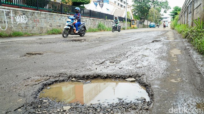 Kerusakan parah terlihat di ruas Jalan Gedoran, Depok, Jumat (13/2/2026). Jalan ini merupakan akses menuju Stasiun Depok Baru dan Terminal Depok Baru sekaligus jalur keluar masuk angkutan umum.