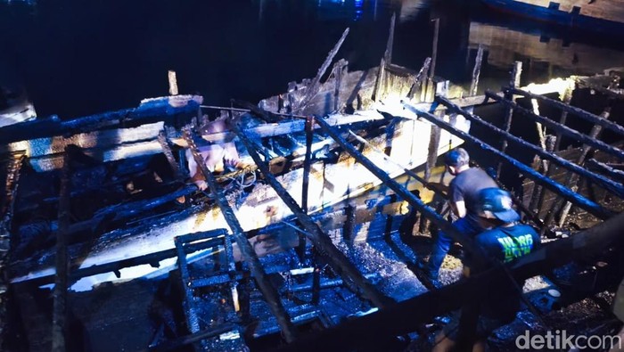 Petugas memadamkan api pada kapal wisata di pelabuhan Marina Labuan Bajo, Manggarai Barat, NTT, Jumat (13/2/2026) dini hari.