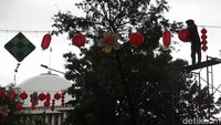 Sejumlah pekerja memasang ornamen Imlek berupa lampion dan hiasan berbentuk kuda yang melambangkan Tahun Kuda Api, Jumat (13/2/2026).  