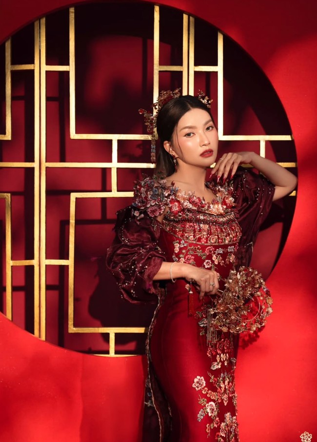 Sarwendah mengenakan gaun panjang warna merah marun dengan potongan klasik. Bagian atasnya dihiasi bordir bunga, manik-manik, dan payet berkilau. Area bahu hingga dada dipenuhi aplikasi bunga 3D dan kristal, membuat tekstur busana tampak hidup. Foto: Instagram/@sarwendah29