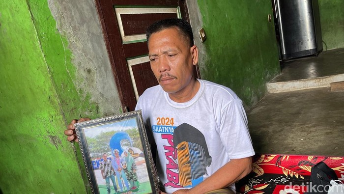 Sulaiman saat memegang foto wisuda anaknya dari sekolah pelayaran. (Foto: Finta Rahyuni/derikSumut)