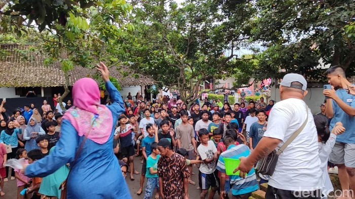 Yang diperebutkan bukan gunungan makanan atau hasil bumi tapi berebut uang koin.
