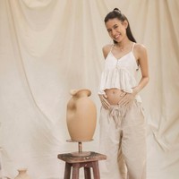 Dalam maternity shoot kali ini, Shenina mengenakan flare crop top warna putih dan celana panjang khaki yang kasual. Bahkan hanya dilengkapi sandal gladiator yang sederhana namun manis. Foto: Dok. Instagram Shenina Cinnamon