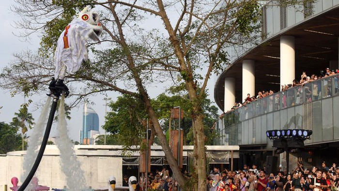 Seorang anak memberikan angpao pada barongsai saat atraksi Aerial Lion Dance di Danau Senayan Park, Jakarta, Sabtu (14/2/2026). Atraksi barongsai menari di atas air yang berlangsung 14-17 Februari 2026 pukul 17.00 dan 19.00 WIB tersebut diselenggarakan pihak mal untuk menyemarakkan perayaan Tahun Baru Imlek 2577 Kongzili. ANTARA FOTO/Indrianto Eko Suwarso/rwa.
