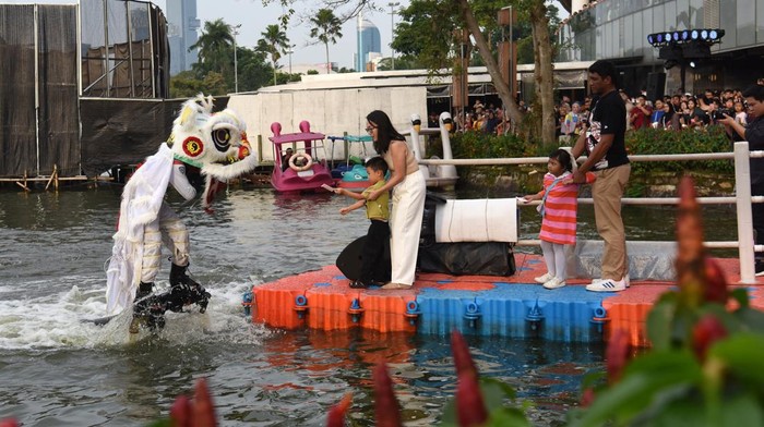 Seorang anak memberikan angpao pada barongsai saat atraksi Aerial Lion Dance di Danau Senayan Park, Jakarta, Sabtu (14/2/2026). Atraksi barongsai menari di atas air yang berlangsung 14-17 Februari 2026 pukul 17.00 dan 19.00 WIB tersebut diselenggarakan pihak mal untuk menyemarakkan perayaan Tahun Baru Imlek 2577 Kongzili. ANTARA FOTO/Indrianto Eko Suwarso/rwa.