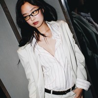 Rambut hitamnya dibiarkan tergerai natural, memberikan kesan effortless chic lengkap dengan bayonetta glasses. Foto: dok. Instagram @jennierubyjane