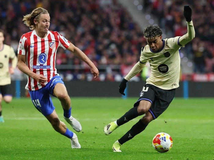 Atletico Madrid's Spanish midfielder #14 Marcos Llorente and Barcelona's Spanish forward #10 Lamine Yamal fight for the ball during the Spanish Copa del Rey (King's Cup) semi final first leg football match between Club Atletico de Madrid and FC Barcelona at Metropolitano Stadium in Madrid on February 12, 2026. (Photo by Pierre-Philippe MARCOU / AFP)