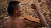 Abdul Rozak (38) menunjukkan ototnya dengan batu bata di lio Cibarusah, Kabupaten Bekasi. Pekerjaan berat yang dilakukan sehari-hari membuatnya memiliki badan berotot tanpa harus pergi ke tempat kebugaran.