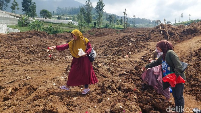 Warga yang anggota keluarganya belum ditemukan tabur bunga di lokasi longsor Cisarua