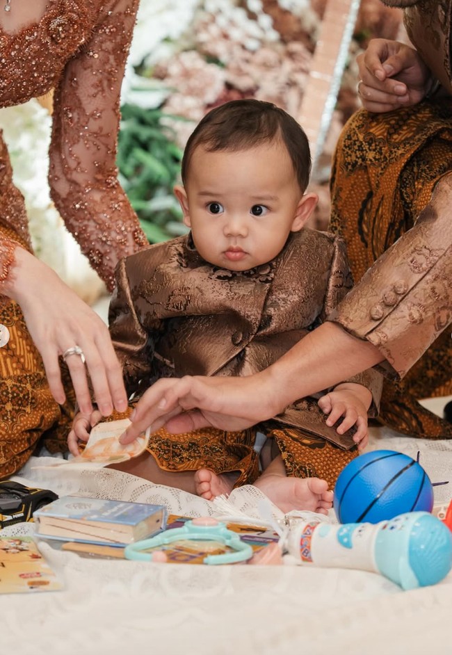 Baby Arash tampil menggemaskan kenakan beskap mini yang dibuat seragam dengan sang ayah. Beskap tersebut dipadukan dengan kain batik senada. Foto: Instagram/@aaliyah.massaid